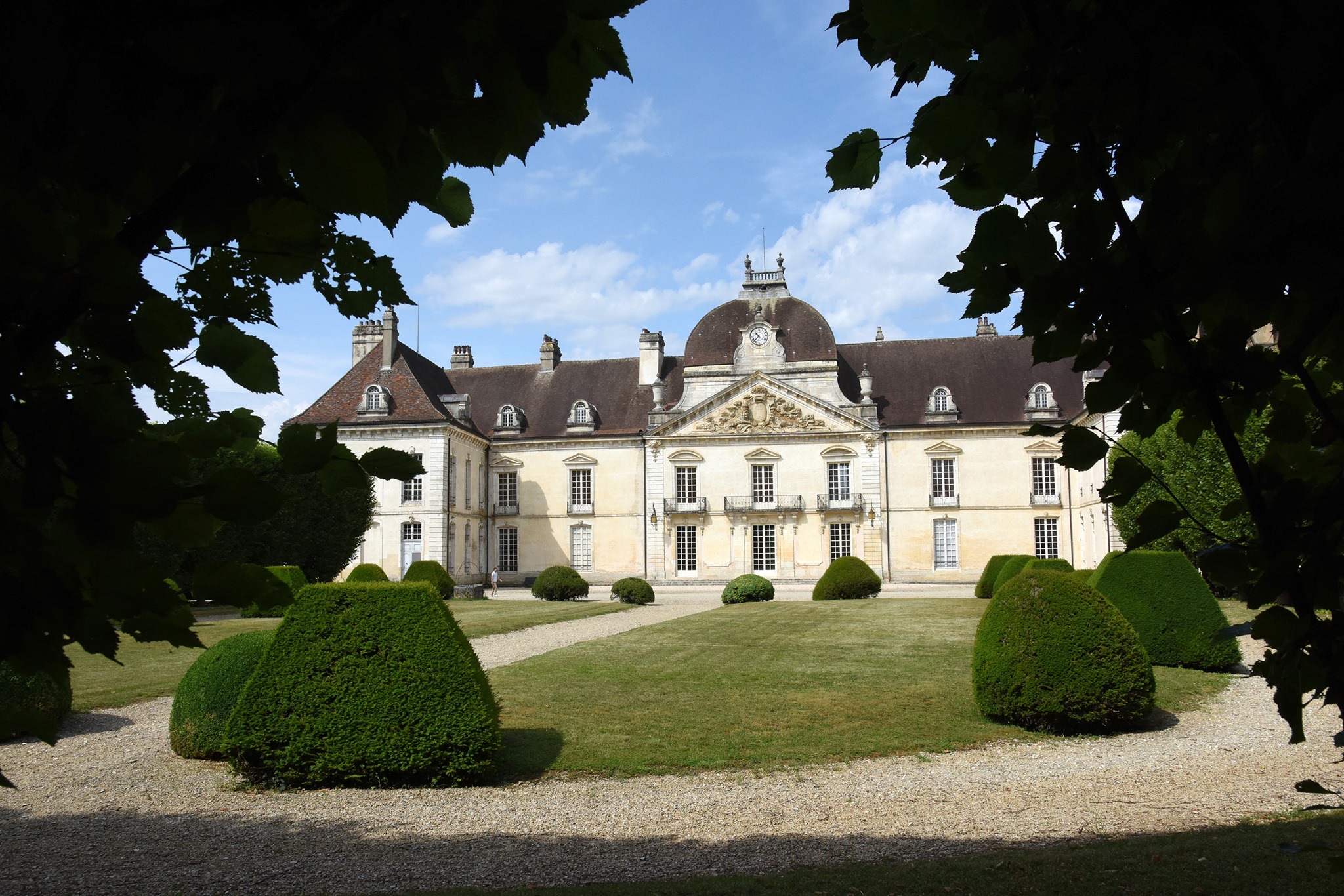 Château de Fontaine-Française encadré par les feuillages du parc
